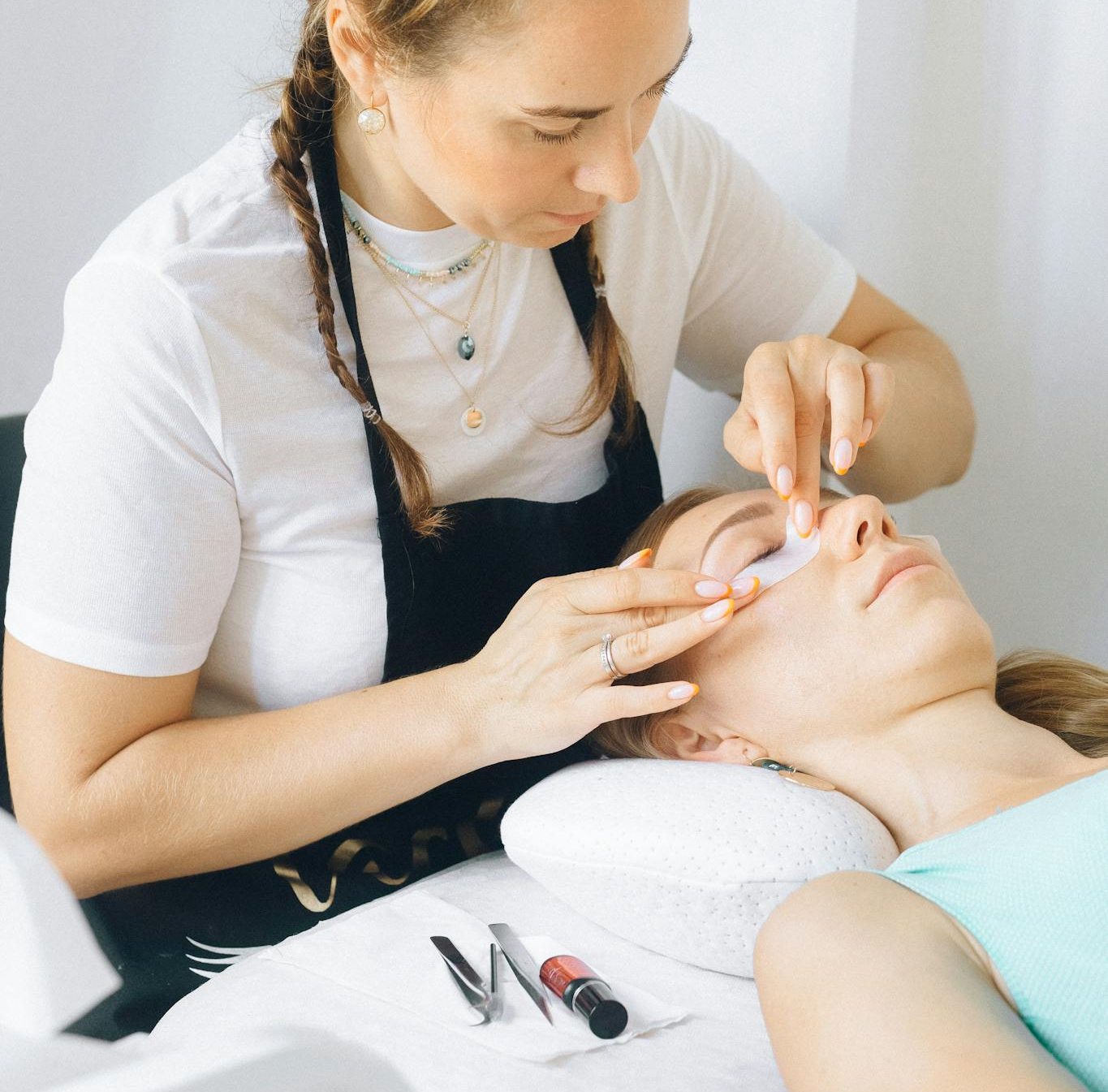 Beauty therapist applies eye treatment in spa setting. Relaxation and professionalism in focus.